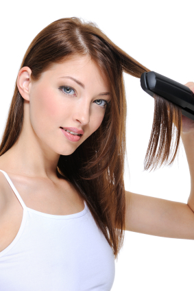 beautiful girl doing hairstyle with hair iron